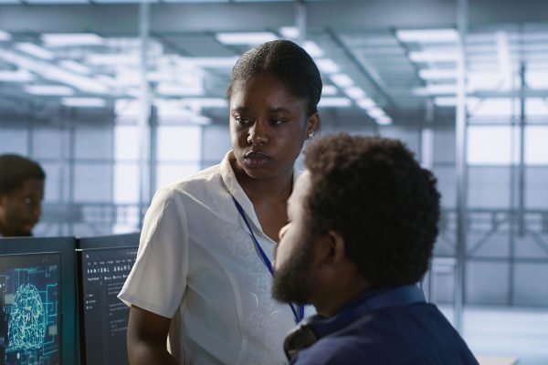 Manager taking feedback from data center engineer maintaining company network infrastructure. Team leader in server hub listening worker ensuring optimal system performance, camera A